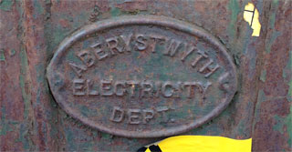 A mark on the front of an electricity box with the words, Aberystwyth Electricity Department